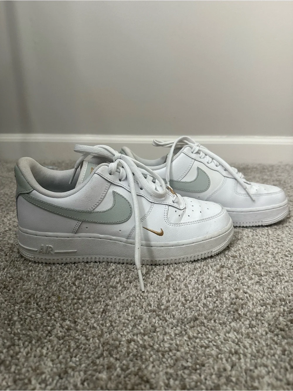 Nike White Sneakers with Sage Green Swoosh and Gold Accent